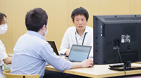 メンバーの仕事の進捗状況を確認するフミタケさん